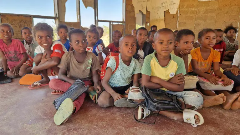 Groupe d'enfants dans une classe, assis à terre - Madagascar - 2025