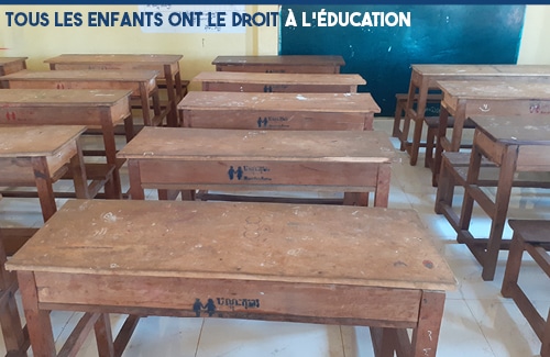 Salle de classe vide avec slogan "Tous les enfants ont le droit à l'éducation"