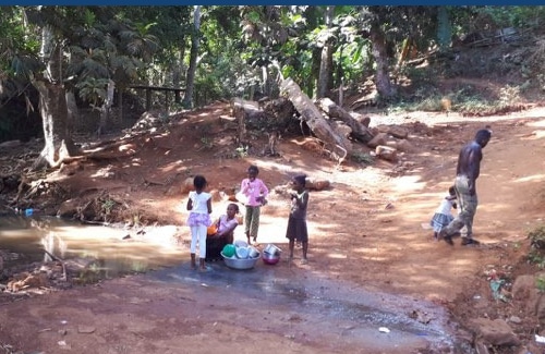 Rue de Mayotte avec des enfants près d'un coin d'eau qui ont fait la vaisselle