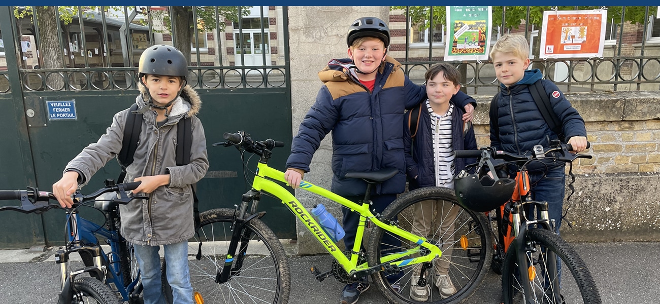 Quatre élèves en vélo devant l'école élémentaire Saint-Lazare à Compiègne dans la cadre de la journée sans voiture